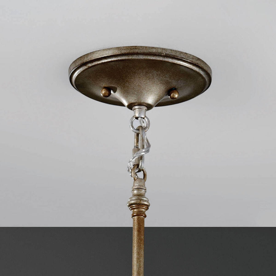 Détail du pavillon rond fixé au plafond, chaîne et raccord métallique patiné.