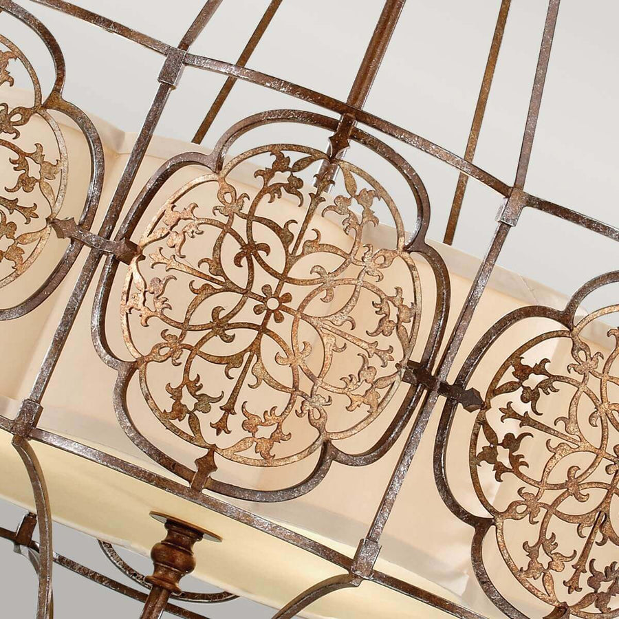 Gros plan sur les motifs floraux ajourés et le verre dépoli du luminaire.