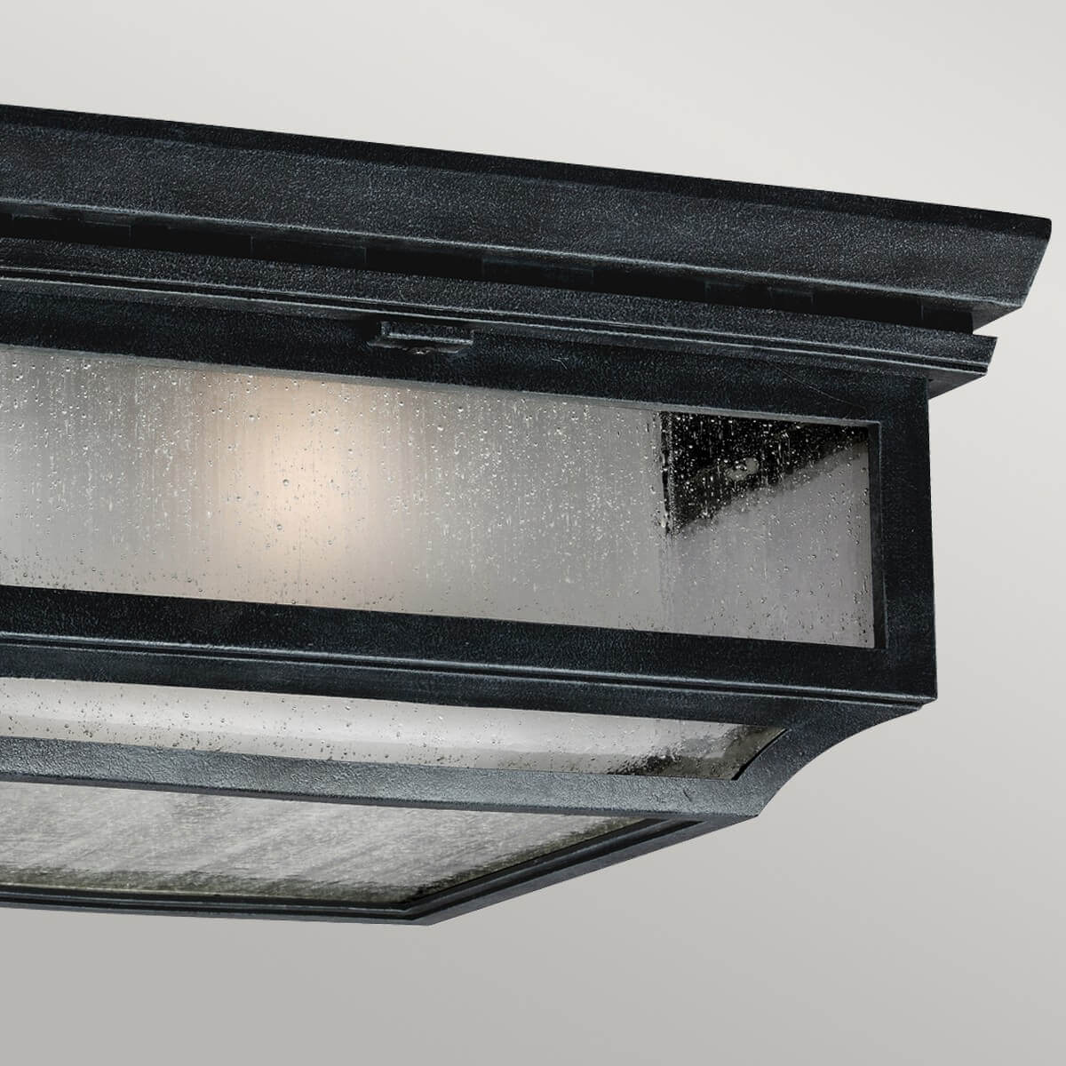 Vue rapprochée du luminaire allumé, verre moucheté et métal texturé