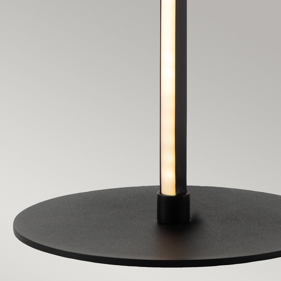 Détail de la base ronde noire mate et du pied vertical lumineux