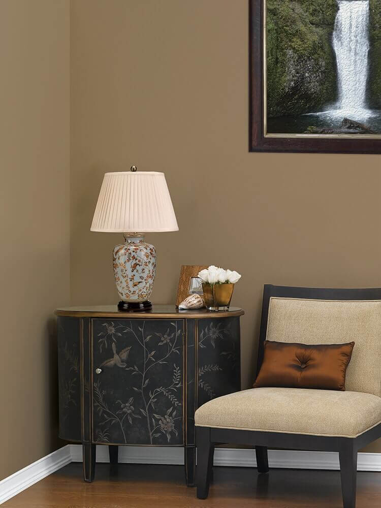 Mise en ambiance sur une commode noire près d'un fauteuil dans un salon