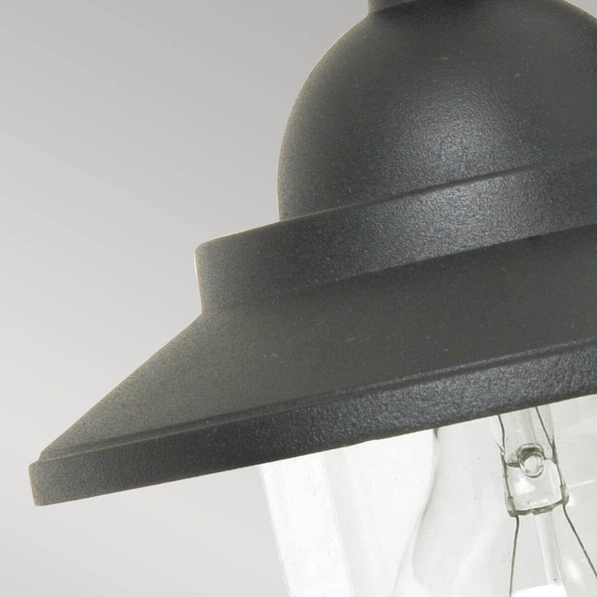 Vue rapprochée du chapeau métallique et de la base du verre transparent.