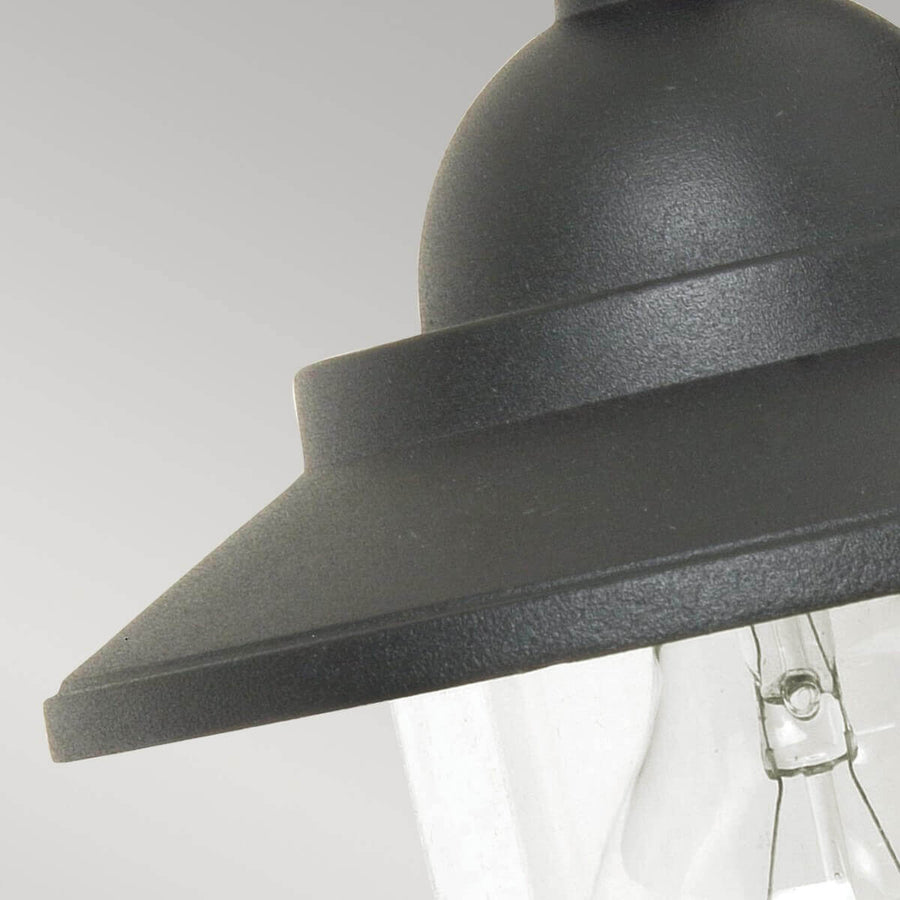 Vue rapprochée du chapeau métallique et de la base du verre transparent.