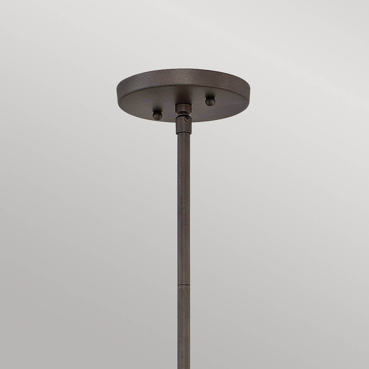 Détail de la rosace ronde fixée au plafond et du départ de la tige métallique.