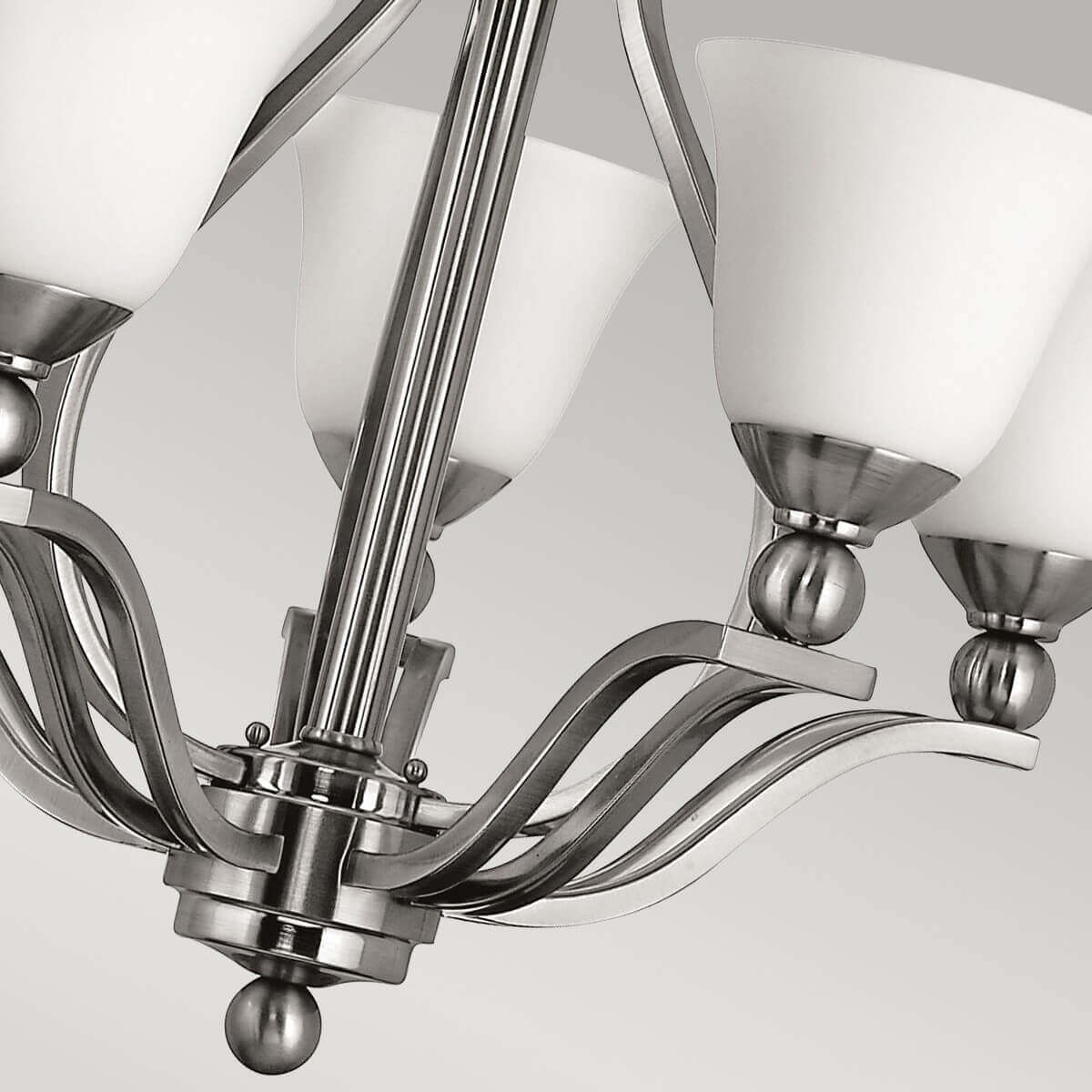 Détail du bas du luminaire avec bras courbes et finition bille nickel