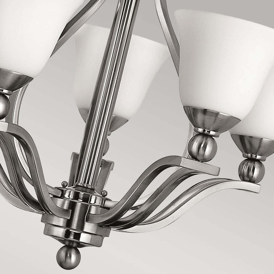 Détail du bas du luminaire avec bras courbes et finition bille nickel