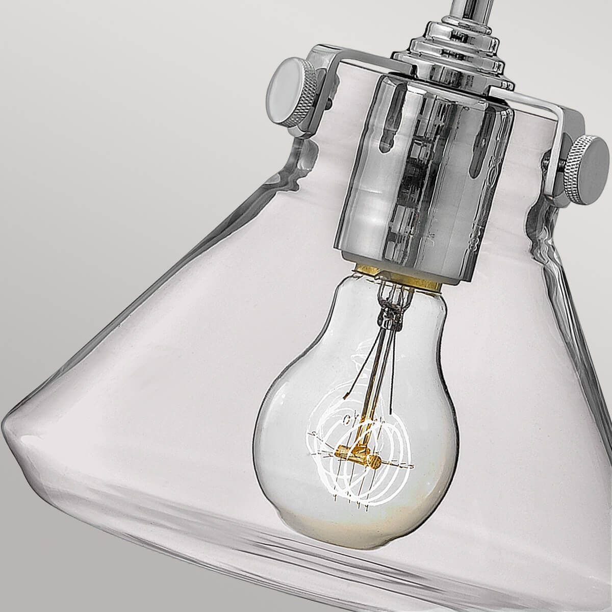 Détail du culot chromé, de l'ampoule à filament et du verre transparent en forme de cône.