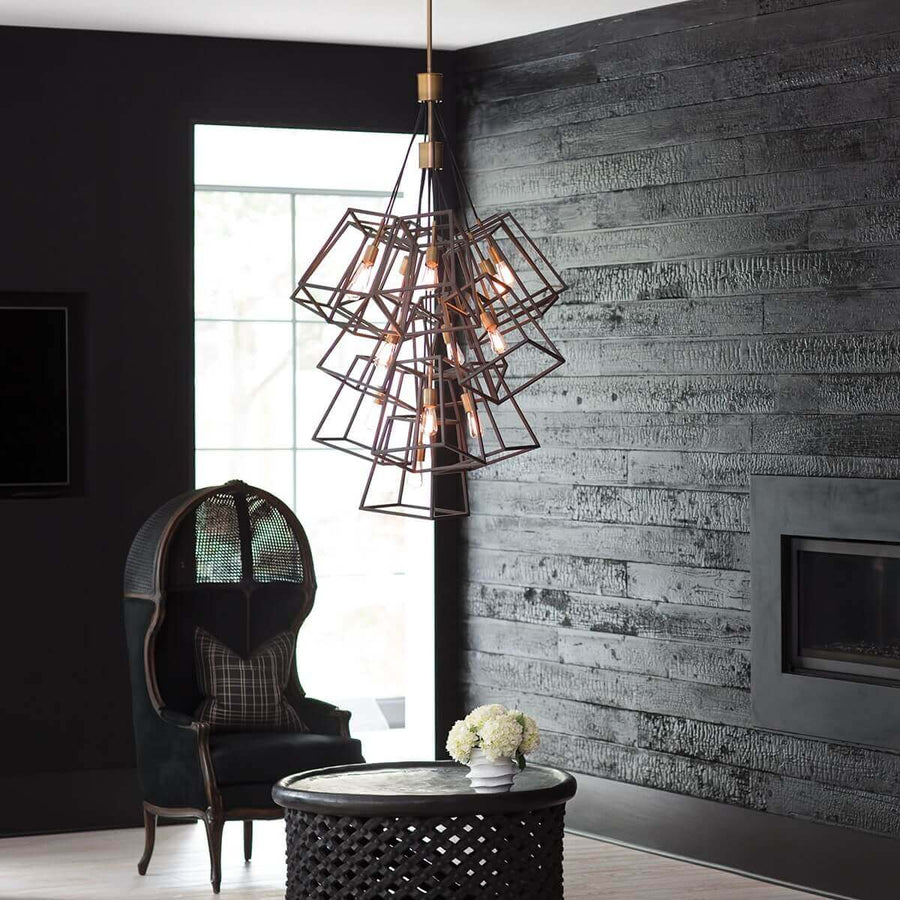 Même suspension géométrique éclairée, intégrée à un intérieur industriel avec fauteuil noir et table basse.
