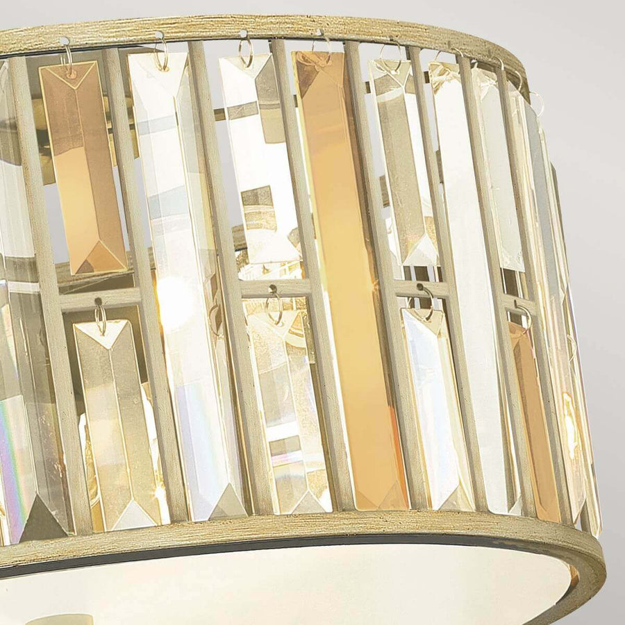Gros plan sur les pendentifs en cristal facetté suspendus à la monture métallique argentée.