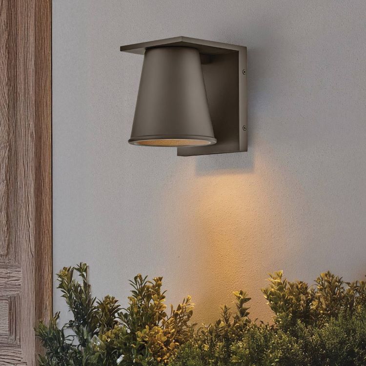 Mise en ambiance sur un mur extérieur, applique allumée éclairant les plantes