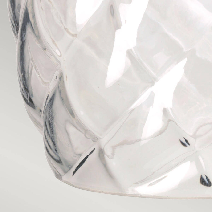 Détail du verre transparent moulé avec facettes losangées et reflets lumineux