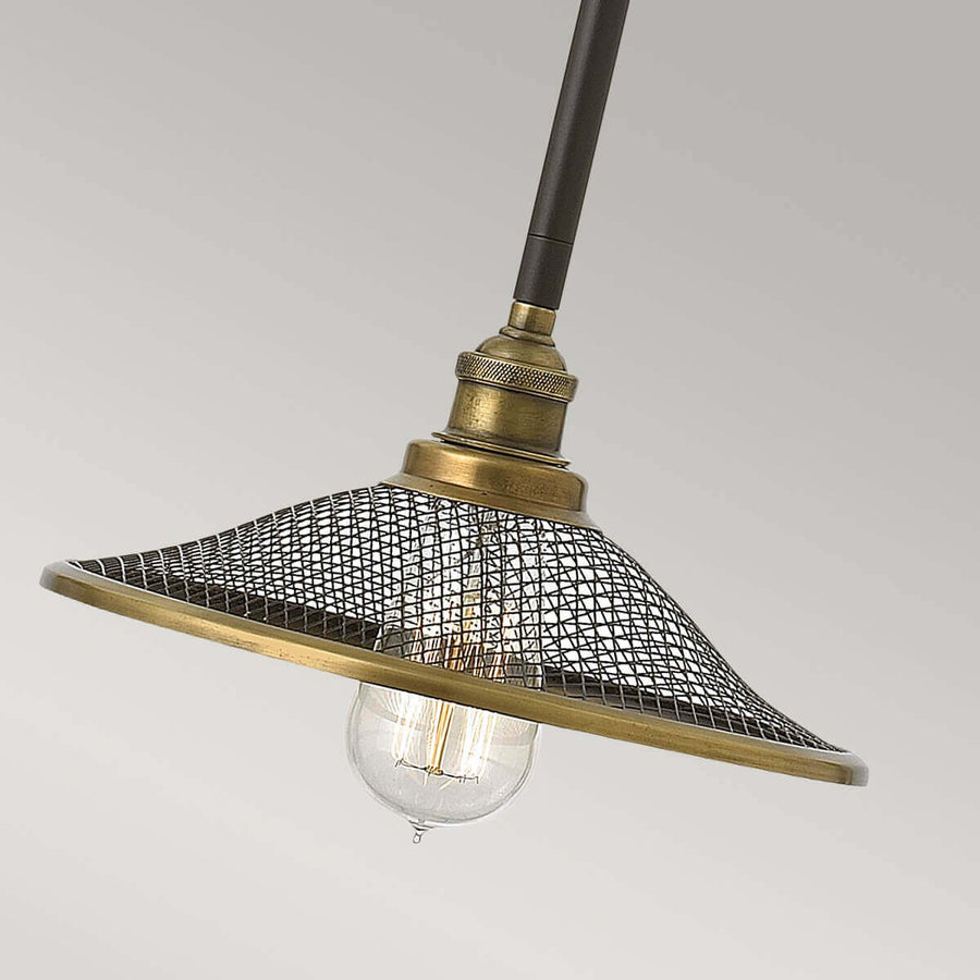 Gros plan sur l'abat-jour en maille métallique bronze et l'ampoule apparente