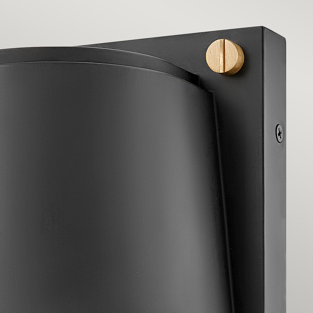 Détail de la vis dorée et du bord supérieur du diffuseur noir