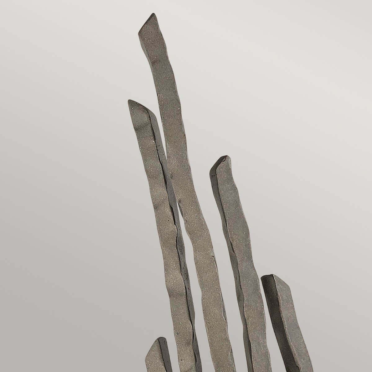 Détail des tiges métalliques martelées, extrémités irrégulières et finition bronze texturée