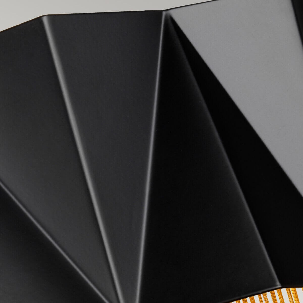 Gros plan sur les plis géométriques du diffuseur noir laqué