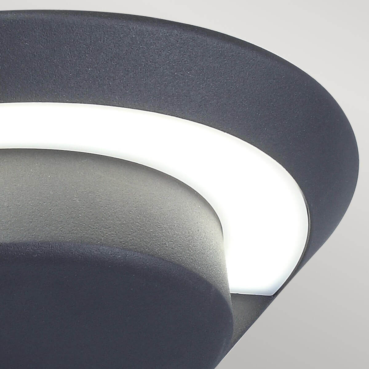 Gros plan sur le diffuseur blanc courbe et la texture granuleuse anthracite