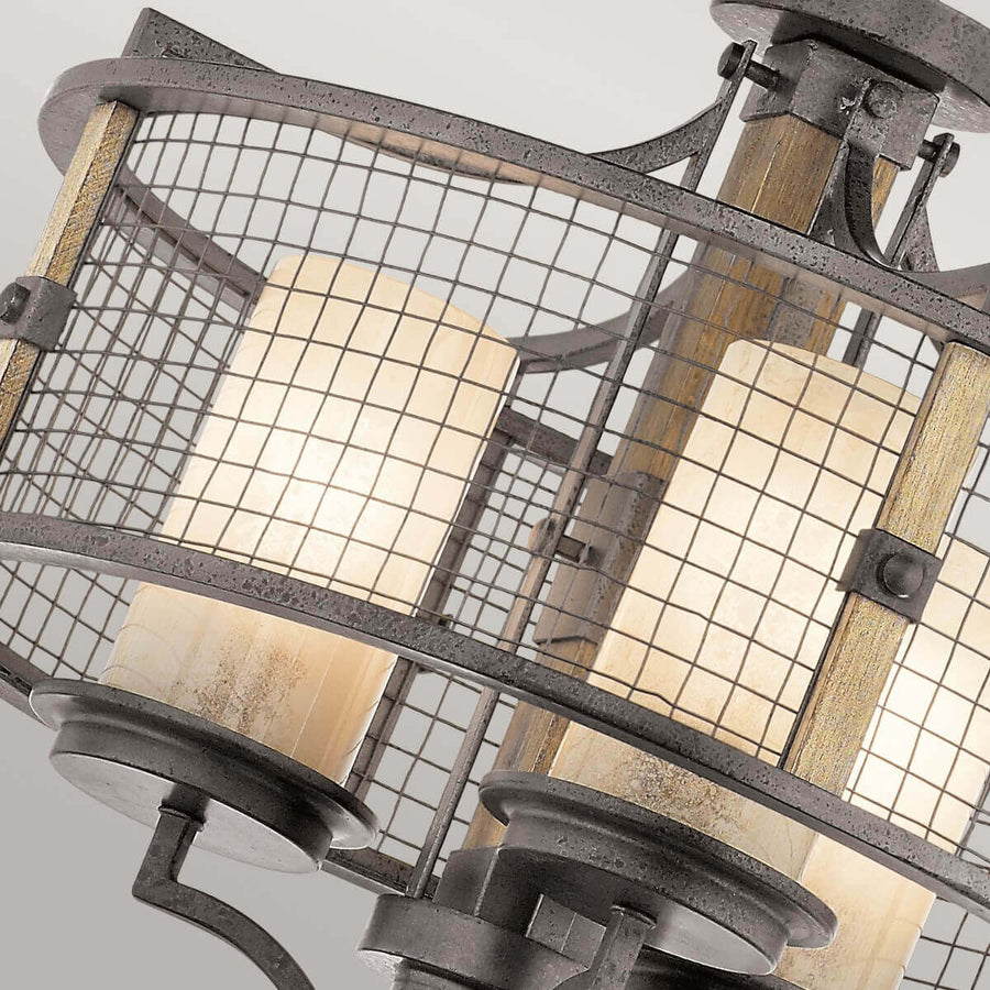 Gros plan sur la cage grillagée, montants en bois et verre ambré éclairé