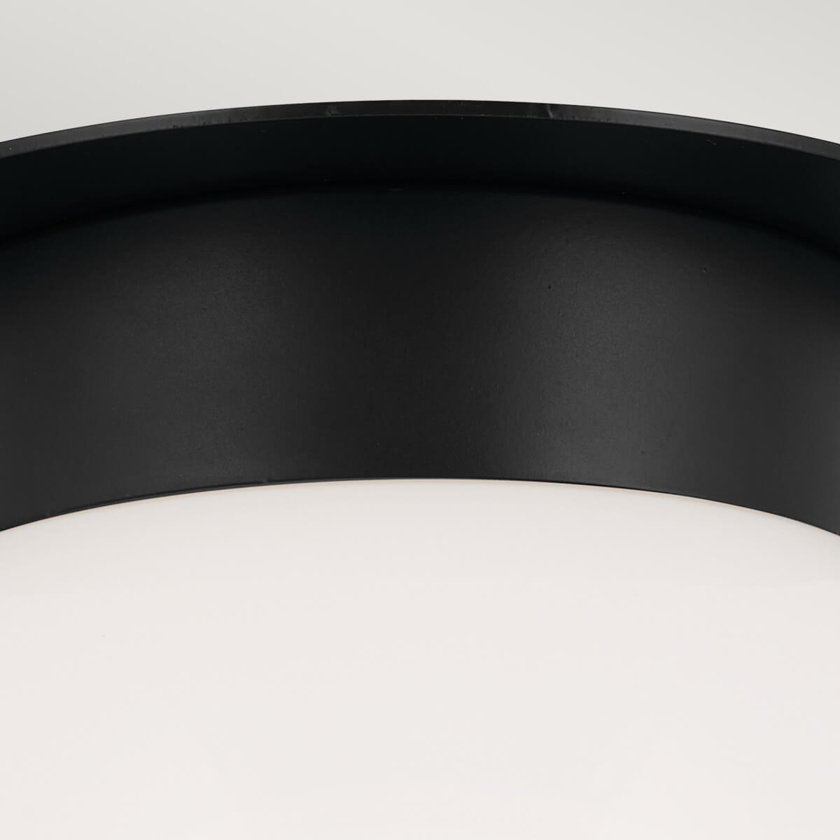 Détail de l'assemblage entre la platine noire et la calotte en verre blanc.