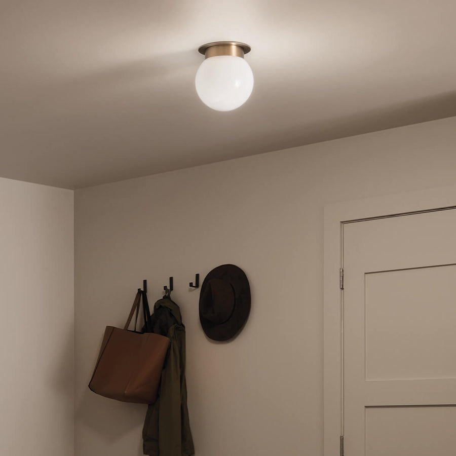 Luminaire éclairé vu en plongée diffusant une lumière chaude dans un couloir