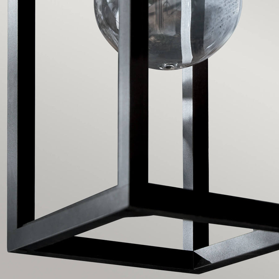 Vue rapprochée du bas du cadre carré noir et du verre arrondi