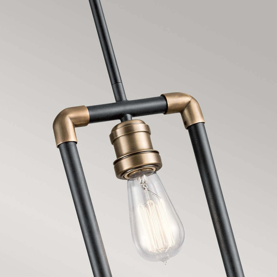 Gros plan sur le raccord central, la douille et l'ampoule Edison allumée.