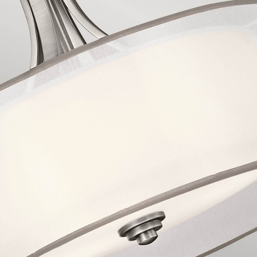 Gros plan sur le culot métallique et le diffuseur intérieur blanc du luminaire.