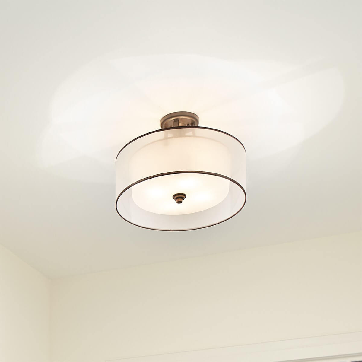 Luminaire allumé fixé au plafond blanc, halo lumineux diffus tout autour
