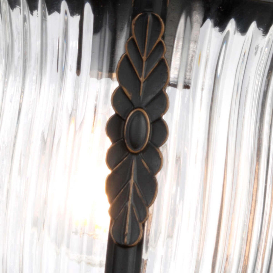 Détail du motif central en forme de feuille devant le verre strié rétroéclairé.