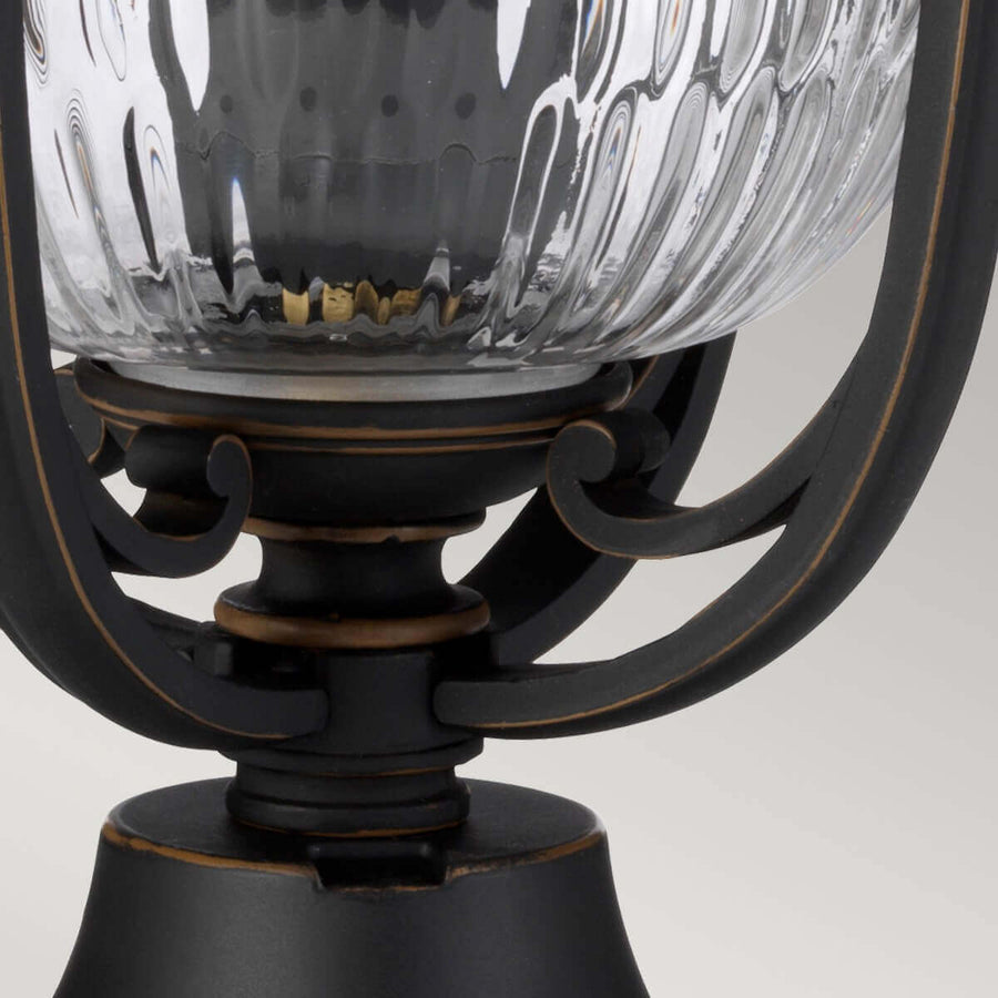 Vue rapprochée du bas du verre et des bras courbes formant cage.