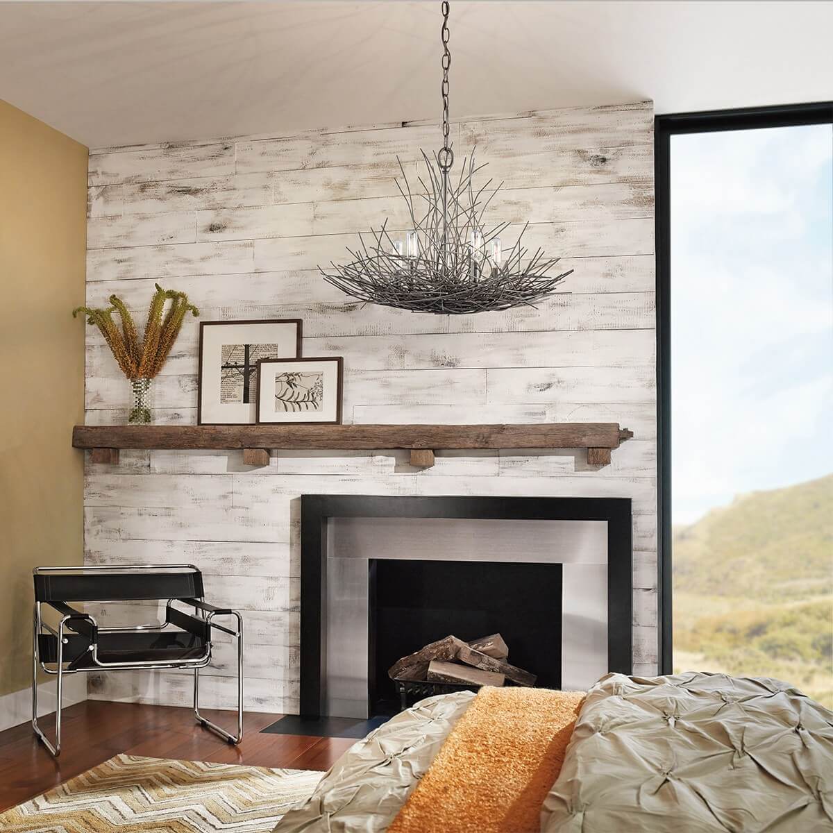 Mise en ambiance : lustre suspendu au-dessus d'une cheminée, mur lambrissé blanc et fauteuil.