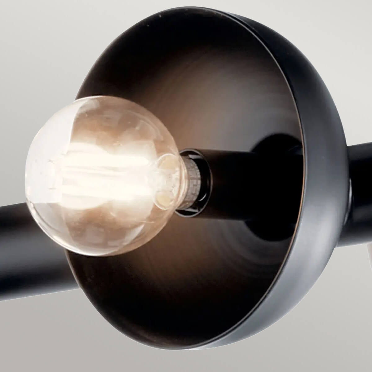 Macro d'une coupelle noire et d'une ampoule à filament allumée