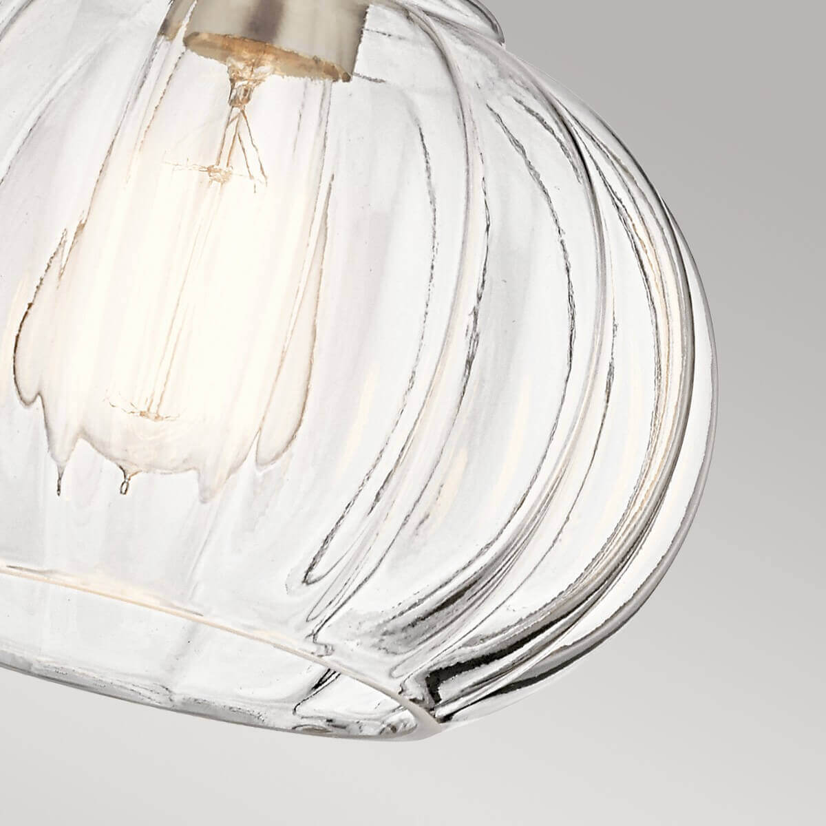 Vue rapprochée du verre godronné transparent laissant voir l'ampoule allumée à l'intérieur
