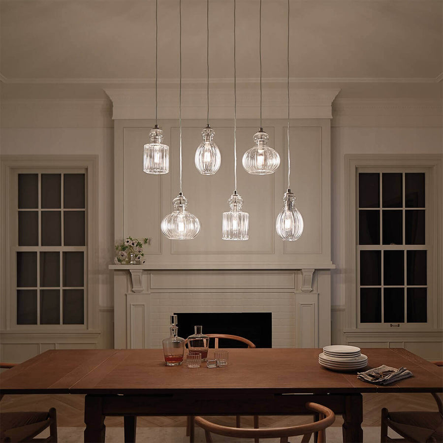 Mise en ambiance nocturne avec six suspensions allumées au-dessus d'une table dressée