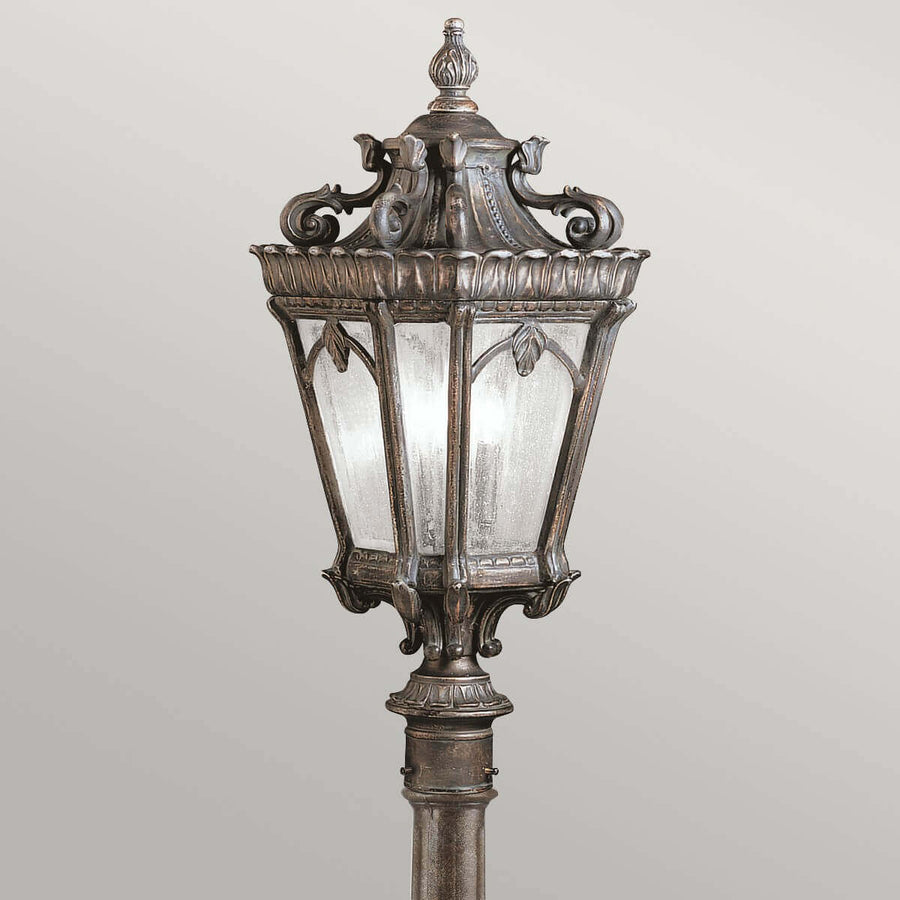 Gros plan sur la lanterne, verre dépoli et ornements de volutes en métal bronze.