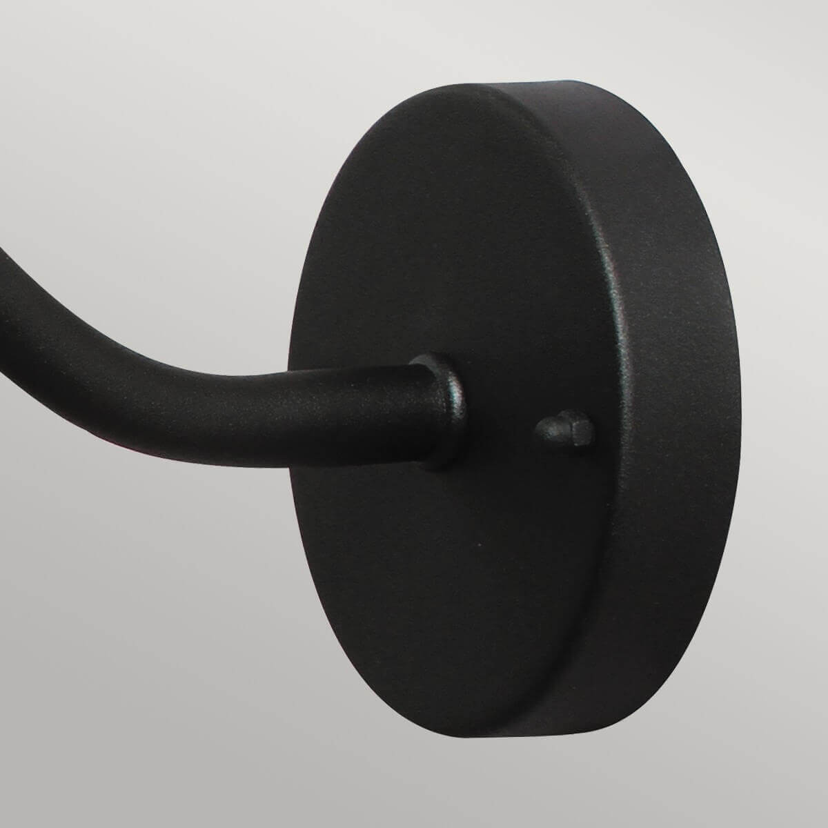 Détail de la platine murale ronde noire fixée par une vis apparente