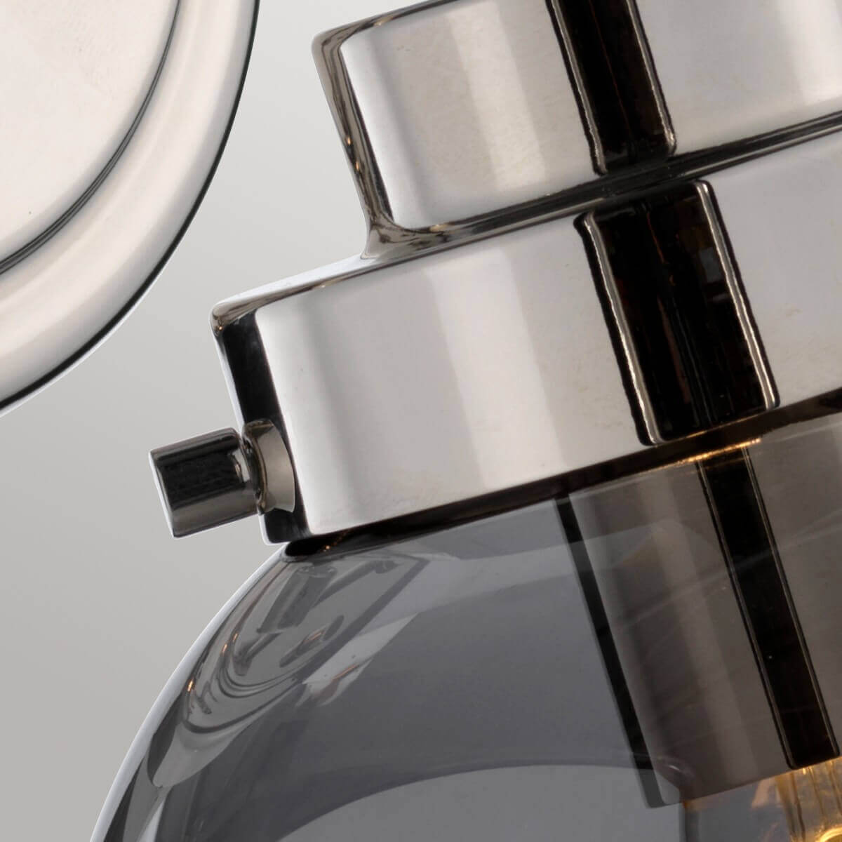 Détail du collier chromé maintenant le globe de verre fumé