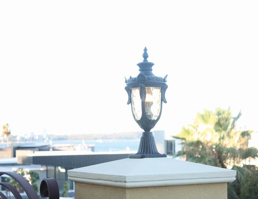 Luminaire installé sur un pilier, vue dégagée sur mer et palmiers
