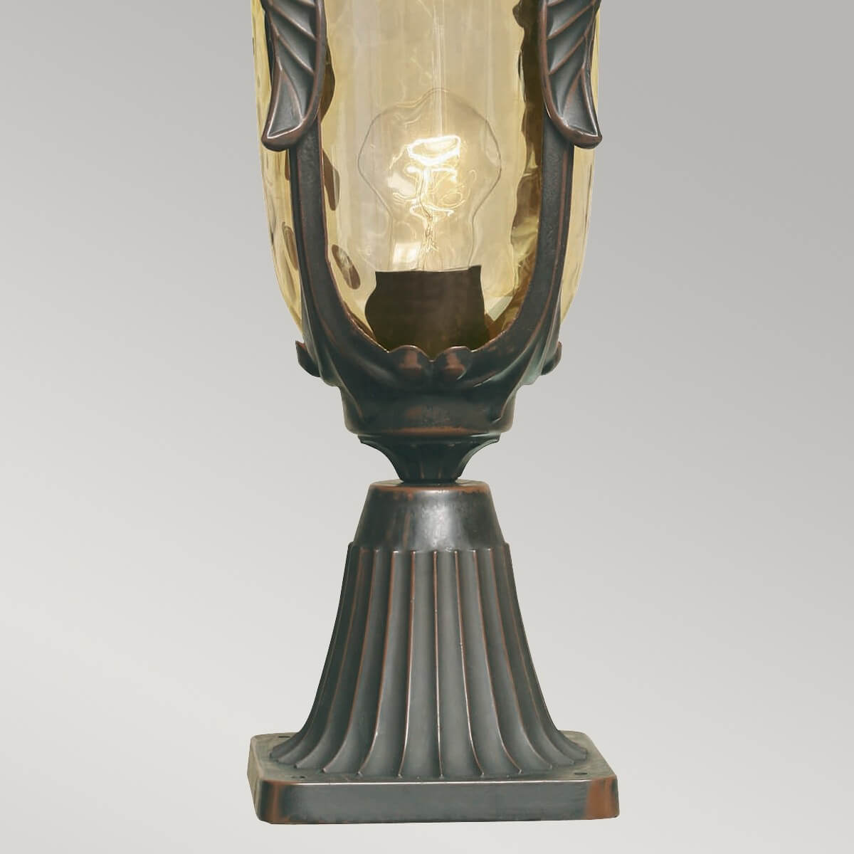 Détail du pied strié et de la base carrée en bronze foncé