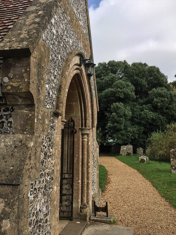 Luminaire installé sur mur de pierre, au-dessus de l'entrée cintrée d'une chapelle