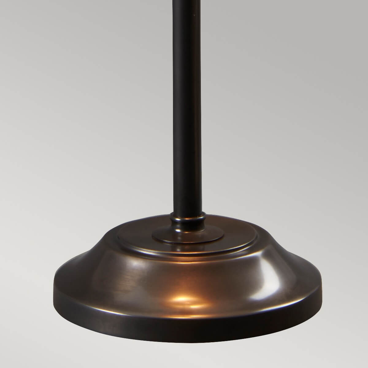 Détail du socle rond et patiné en bronze, tige cylindrique centrale.