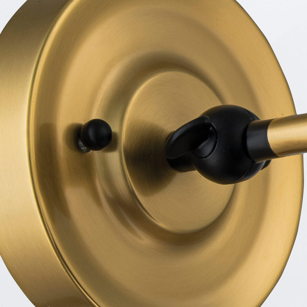 Détail de la rosace ronde en laiton avec rotule et vis noires de fixation