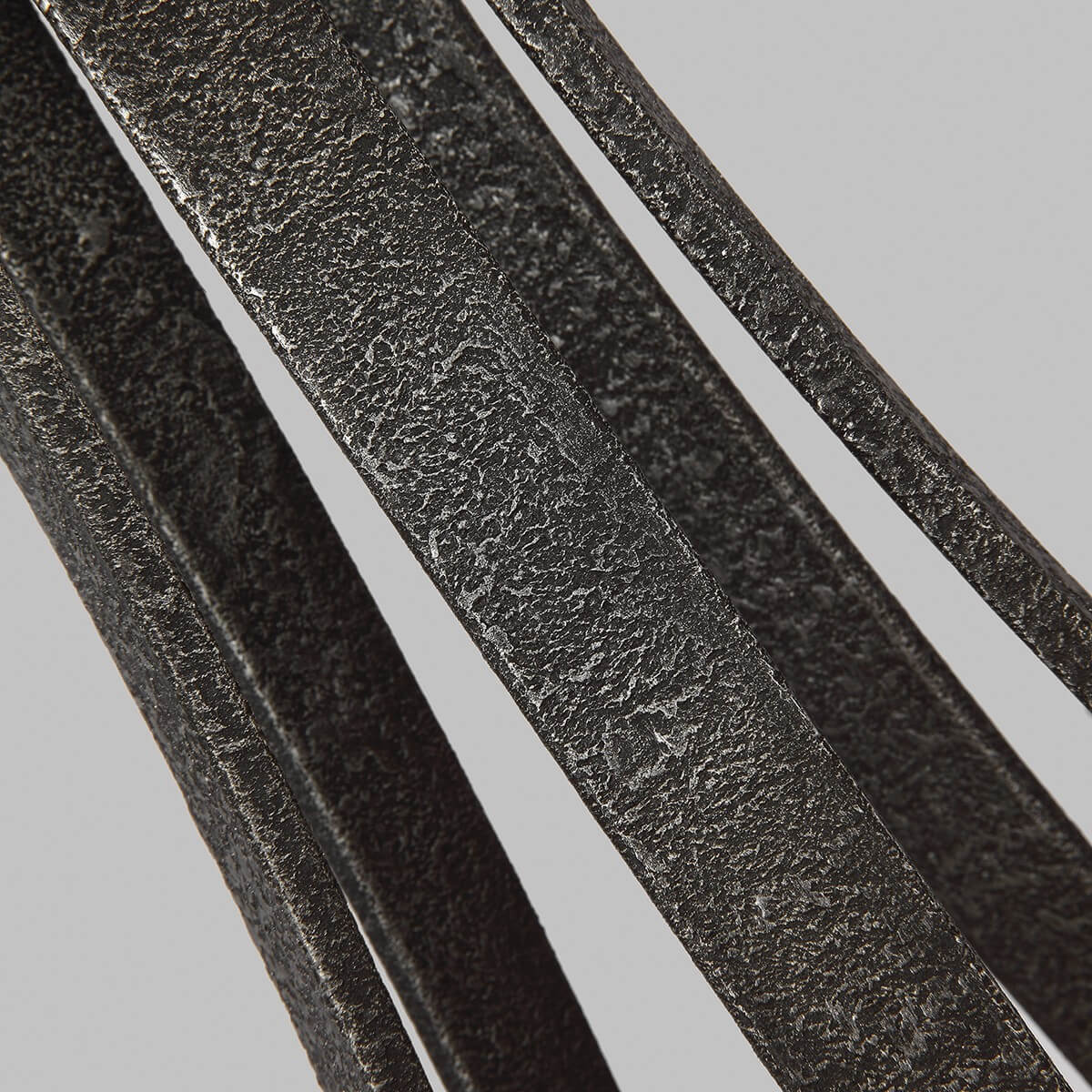 Détail de la finition métal gris texturé des bras incurvés du lustre
