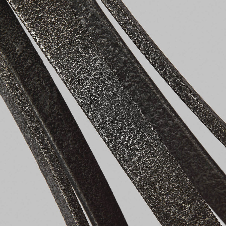Détail de la finition métal gris texturé des bras incurvés du lustre