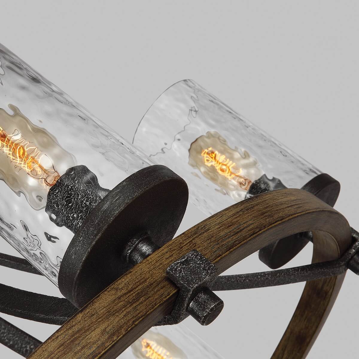 Détail des cylindres en verre martelé, ampoules allumées et fixations métalliques sur bois
