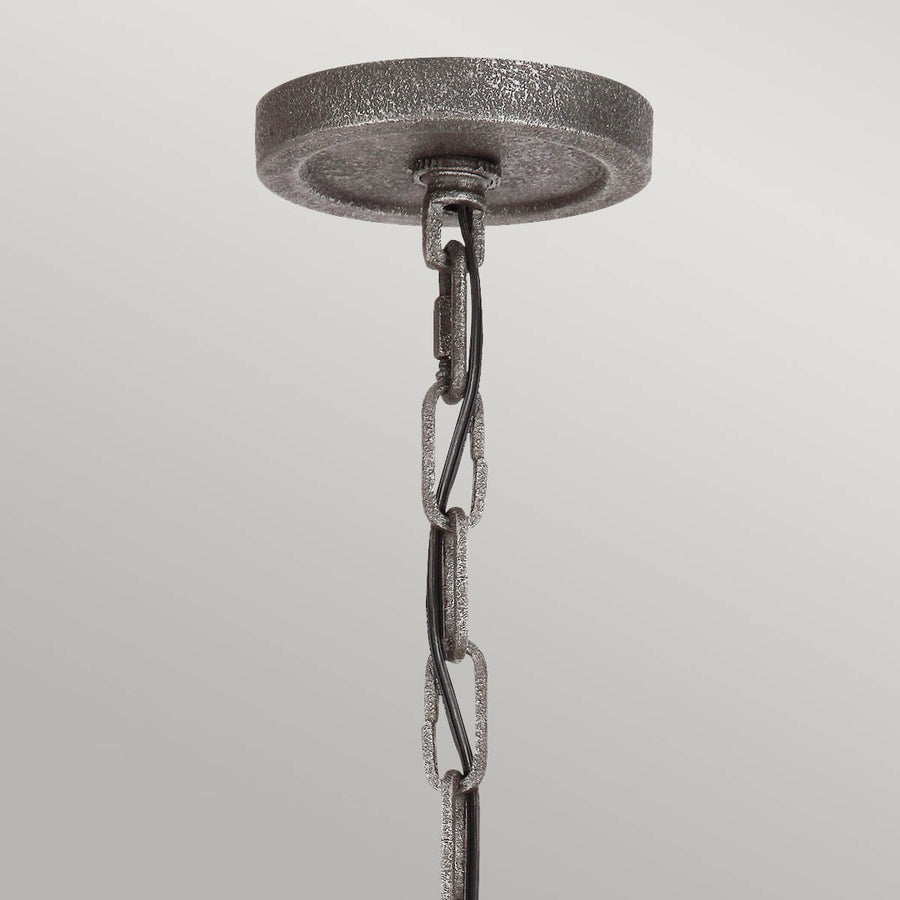 Détail de la rosace ronde et de la chaîne de suspension en métal gris texturé
