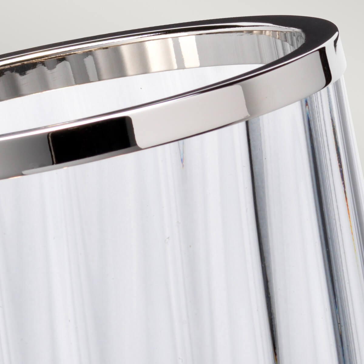 Gros plan sur le cerclage chromé supérieur du cylindre en verre
