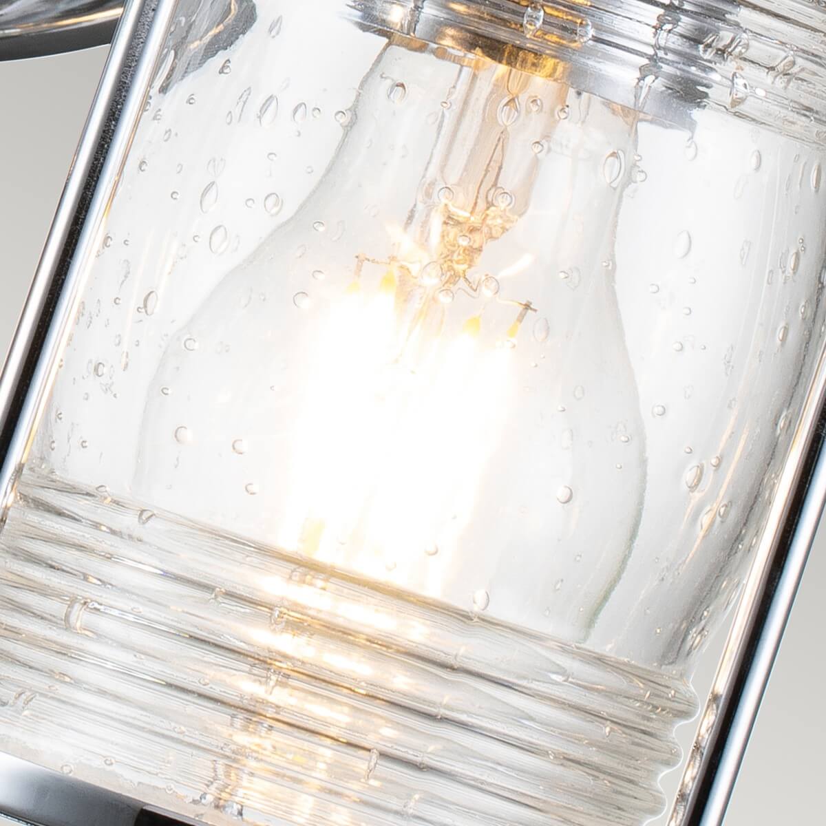 Vue rapprochée de l'ampoule allumée derrière le verre moucheté transparent
