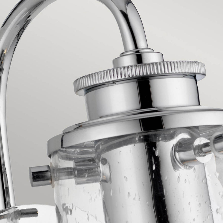 Détail du sommet chromé moleté et des vis maintenant le verre cylindrique