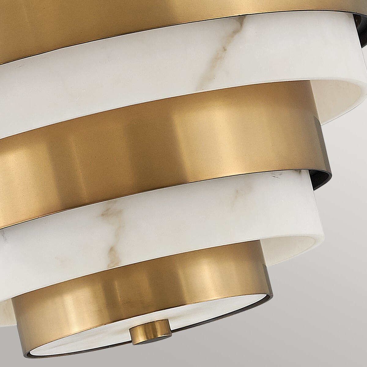 Détail du bas du luminaire avec anneaux en laiton et albâtre, finition centrale.