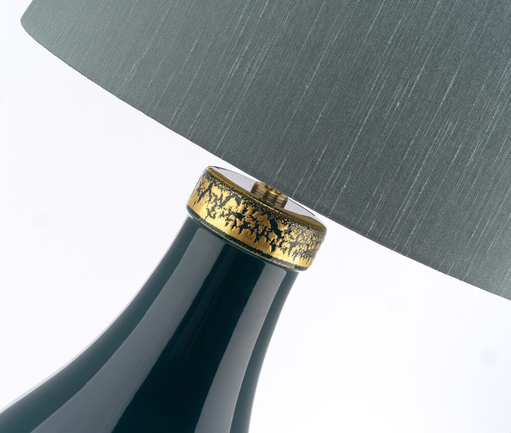 Détail rapproché de la bague dorée ciselée et du col en céramique vernie